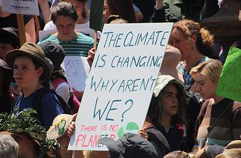 Youth at climate march holding sign: "The climate is changing. Why aren't we?"