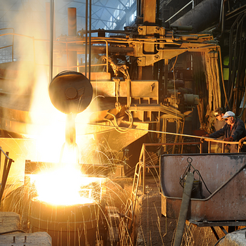 Men pour molten steel at industrial plant