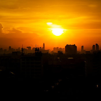 Bright orange sunset over silhouetted urban skyline