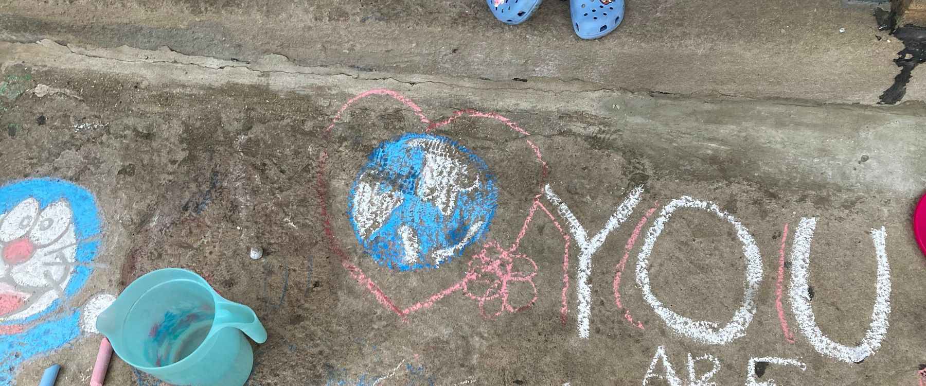 A chalk picture of the world in a heart next to text that reads "you are loved". Project completed by Chicago students as part of Earth Day service.