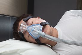 Man with oxygen mask sleeping on bed
