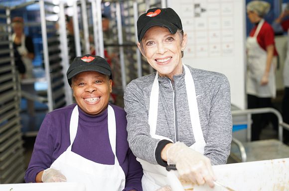 Two volunteers smiling at the camera during a meal packout