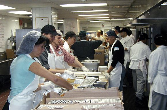 Volunteers standing around tables prepping food in 2001
