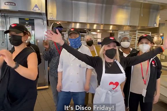 A YouTube screenshot of 7 people in the God's Love kitchen celebrating Disco Friday.