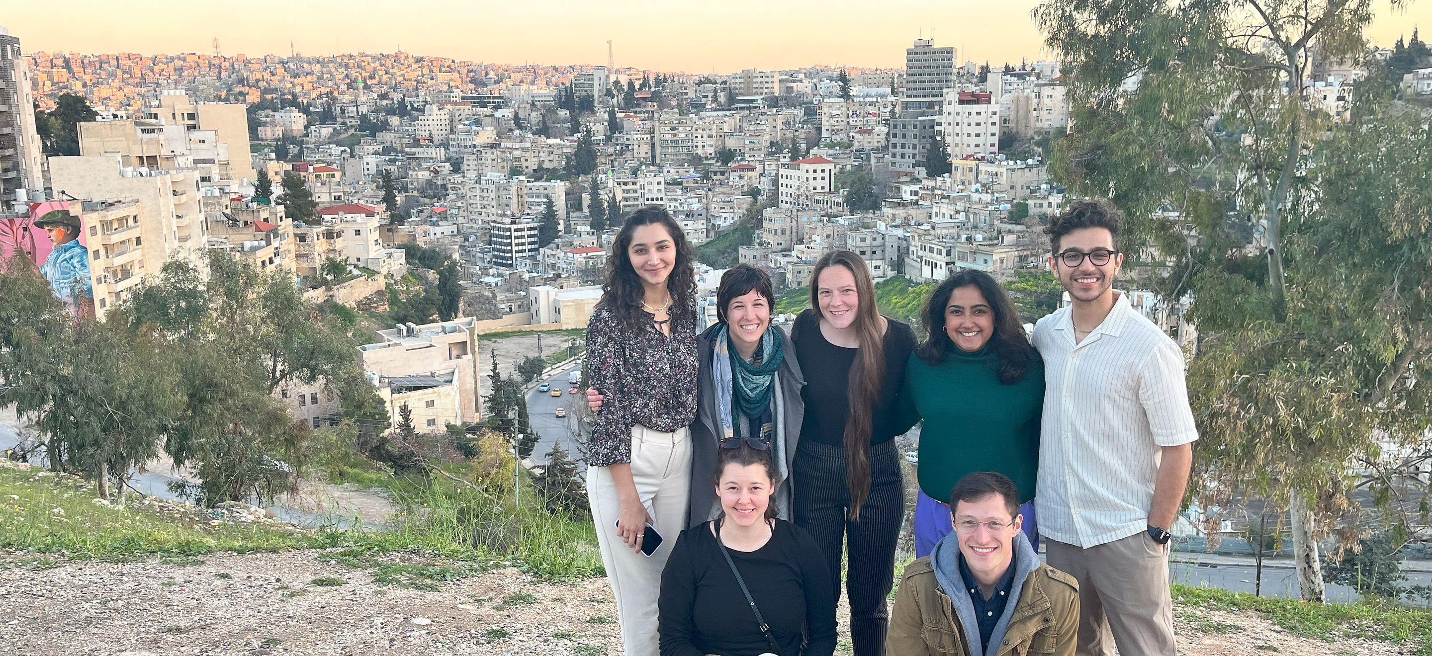 A group of students from IRAP's law school chapters stand against the Amman, Jordan cityscape.