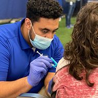 A Creighton University PA student administers the COVID-19 vaccine to a patient.