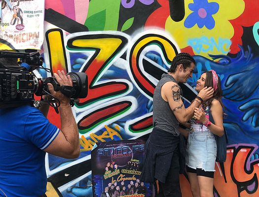 Filming a young couple in front of mural