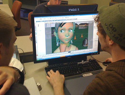 Student working on desktop computer. Computer screen shows an animation design program with a character face in the design process