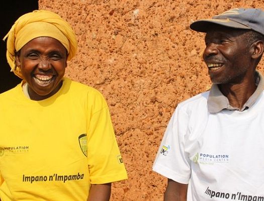 A woman in a yellow shirt and a man in a white shirt laugh together