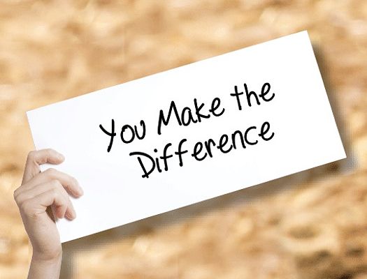 A hand holds up a white sign that says "You Make the Difference"