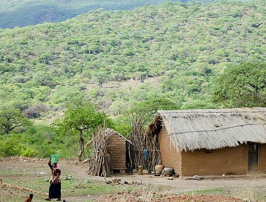 A straw roof house next to a hill in Zambia