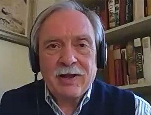 Bob Walker, wearing headphones, speaks to a video conference