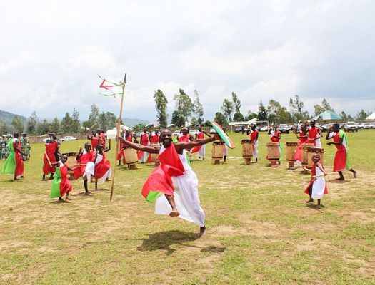 A group of women wearing red and white dresses cheer in a circle
