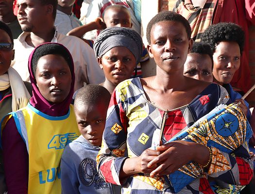 A group of Burundian women and children stare directly into the camera. Photo was taken during a canvassing event hosted by PMC-Burundi