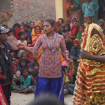 Street Theater performance in Nepal. Five performers surrounded by a large crowd in the middle of the street.