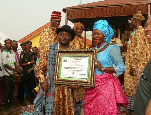 Two Nigerians pose together with a framed certificate