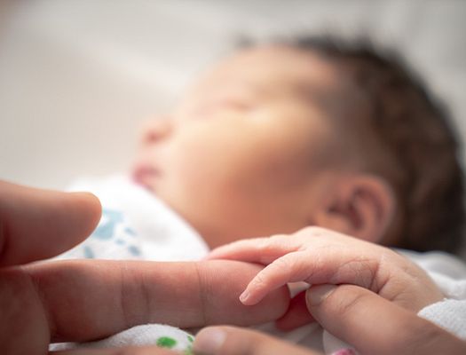 Infant baby holding a finger