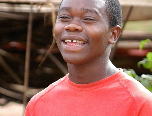Young man in red tshirt smiling and looking forward.
