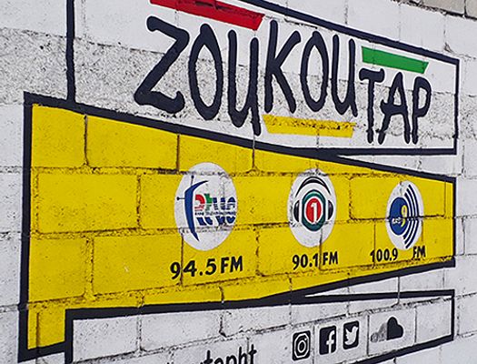 Mural of Zoukoutap logo, radio stations, and social media sites