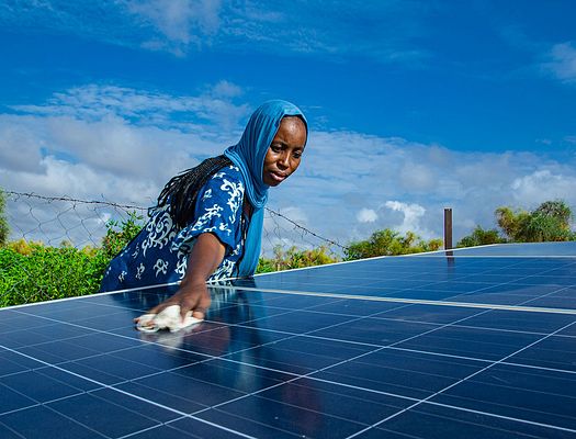 Woman of color taking care of solar panel