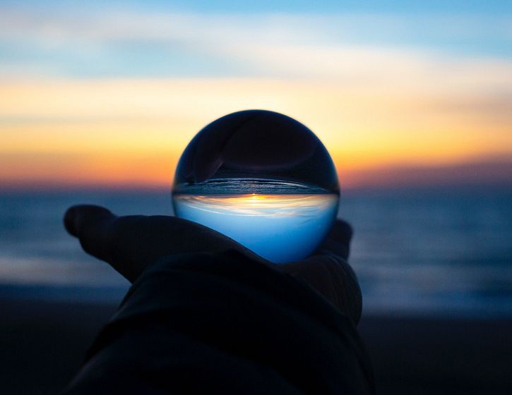 a glass ball with an upside down sunset in it