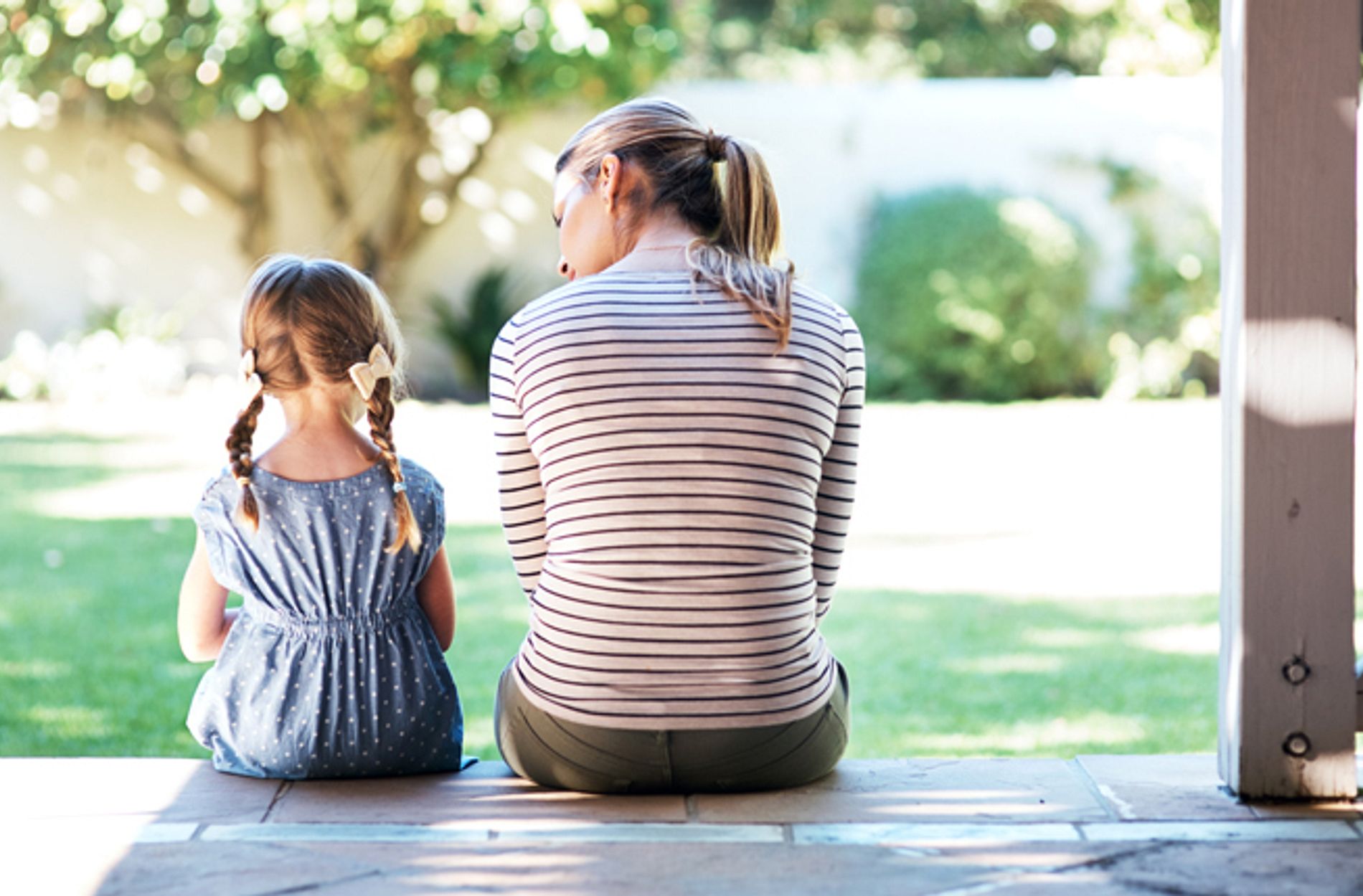 Rearview shot of a young woman and her daughter having a conversation on the porch.