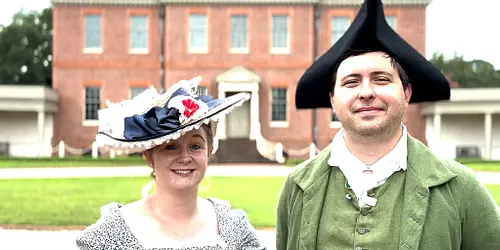 male and female actors dressed in 18th century costumes in front of Tryon Palace in New Bern, NC